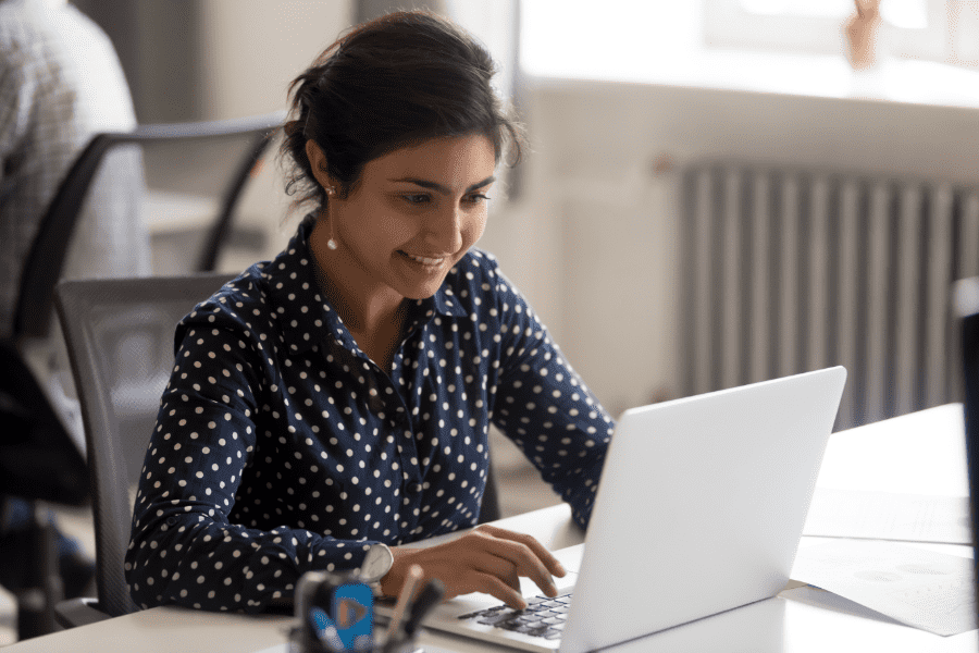 an Indian female employee reading about supplemental benefits on a laptop