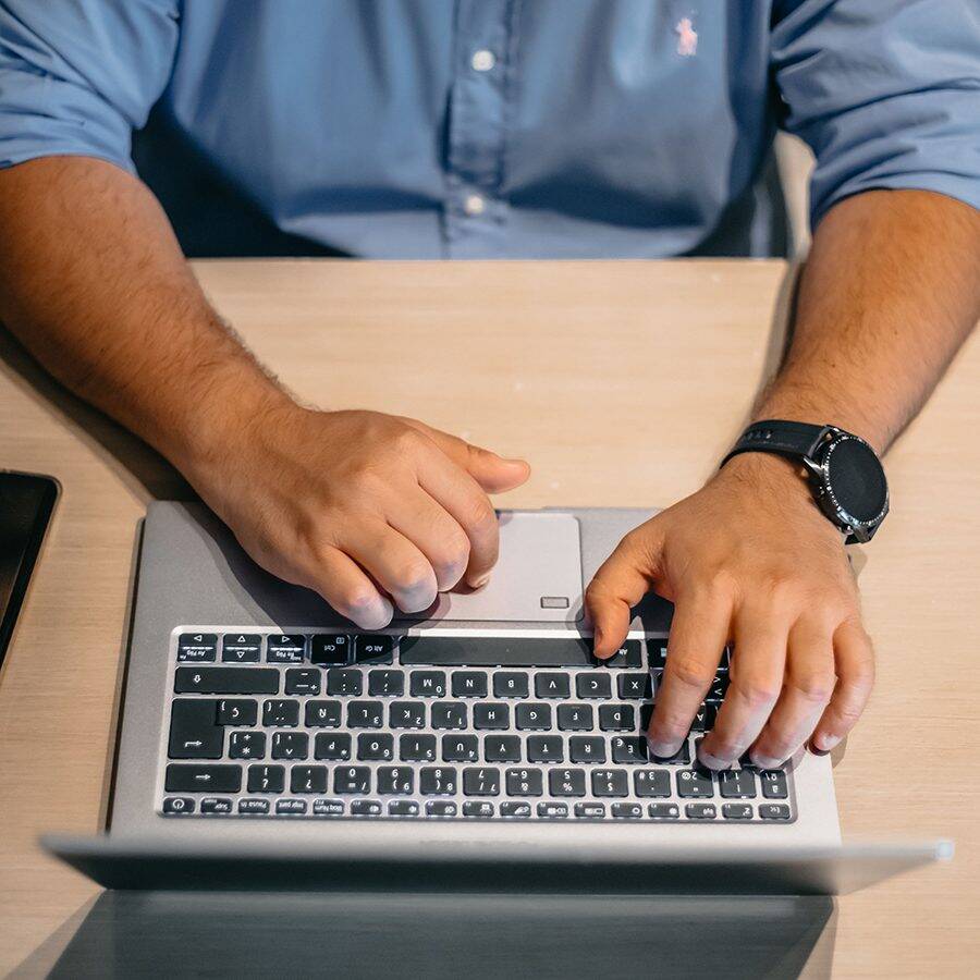 Man with hands on laptop keyboard