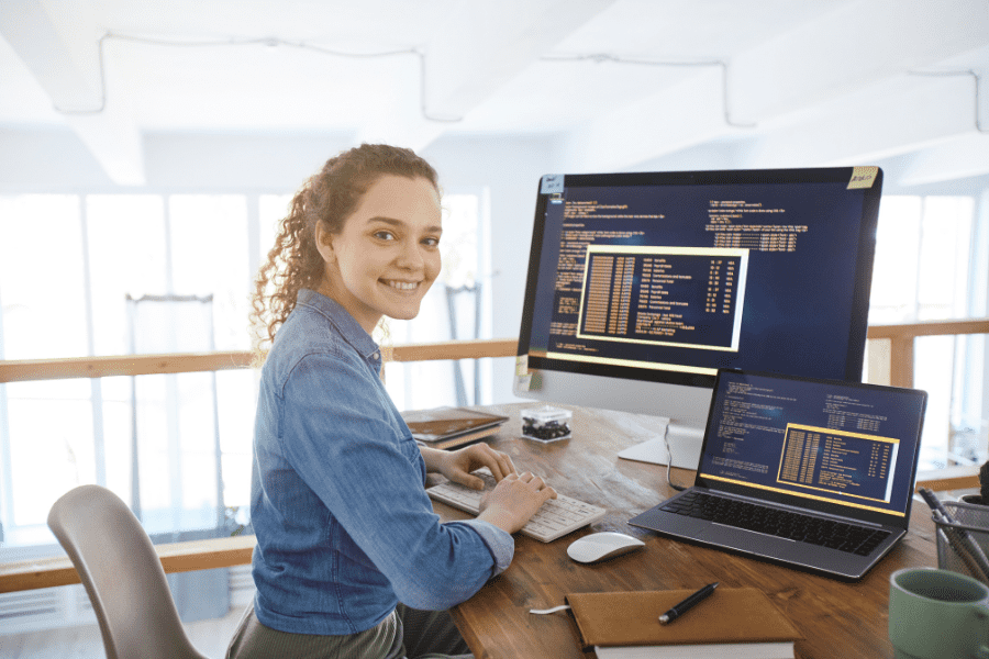female IT developer smiling at camera while working