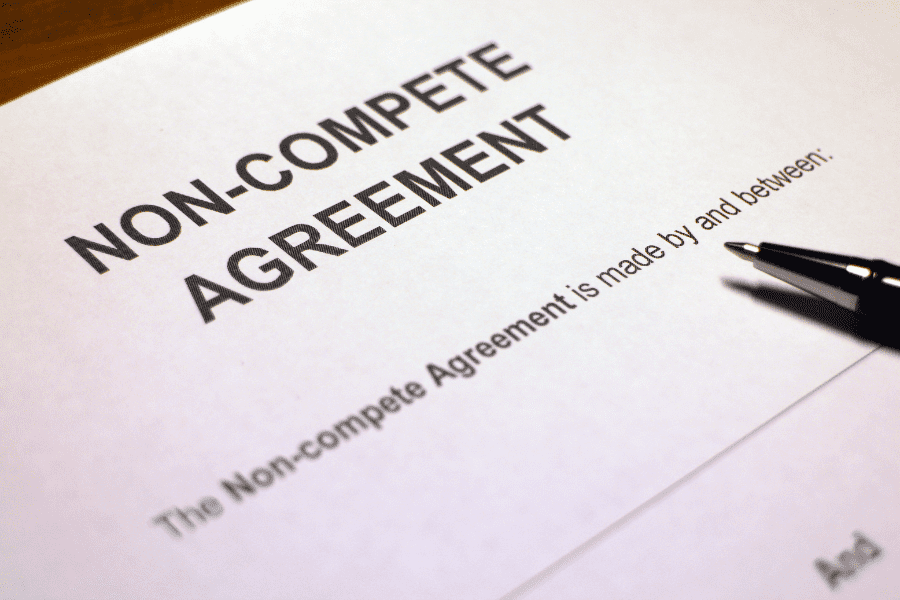 a non-compete agreement with a pen on top of it