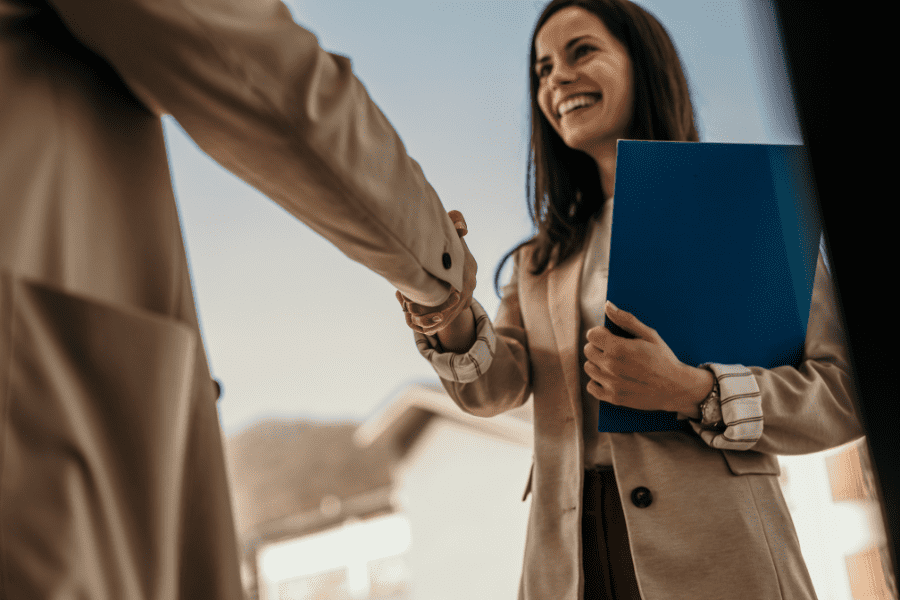 an HR manager shaking hands with a candidate